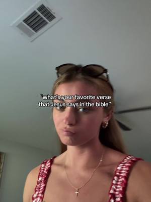 A woman with sunglasses perched on her head is looking slightly downward with a neutral expression. A text overlay reads, "what's your favorite verse that Jesus says in the bible". The background shows a ceiling with recessed lighting and a vent.