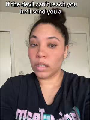 A woman with dark hair and a topknot looks directly at the camera with a neutral expression. Above her is overlaid text in white, against a background of what appears to be a room in a home