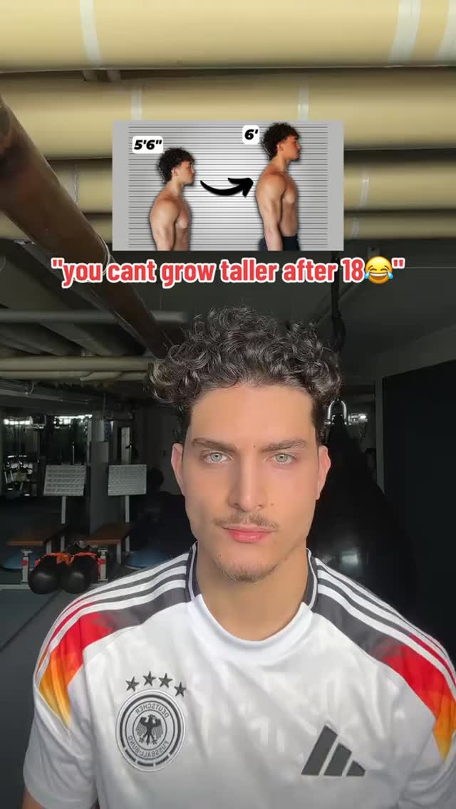 A selfie-style image featuring a young man in a white and black jersey, facing the camera with a slightly closed-mouth smile. Overlayed in the top center is a graphic comparing a figure of 5'6" to a 6' figure using an arrow and a height chart. Below the graphic, there is a text overlay in white, with a yellow laughing emoji at the end of the sentence. The background hints at a gym or fitness environment.