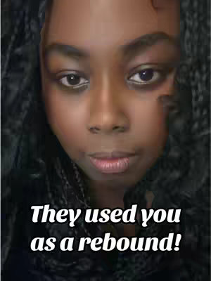 A close-up shot of a young Black woman with dark skin. She has dark, braided hair framing her face. The image has a soft focus, and the background is blurred. Text overlaid at the bottom reads 'They used you as a rebound!' in a stylized white font.