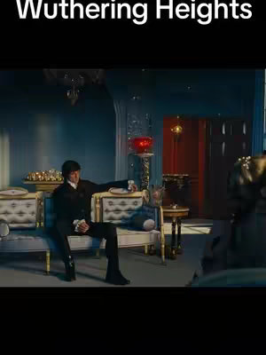 The cover image shows a scene from the movie "Wuthering Heights". A man in a black suit is sitting on a light blue and gold couch in a room with blue walls. There is a large red bowl on a stand in the background.
