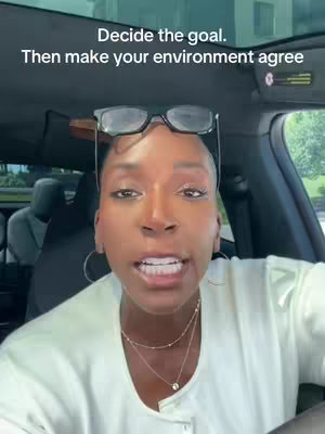 A woman is seated in a car, facing the camera. The upper portion of her face is visible, with the text overlayed on the image. Her hair is pulled back, and she wears eyeglasses perched on her head, a necklace, and earrings. The background is blurred.