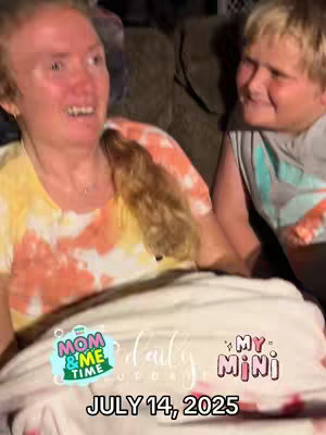 The image shows a candid moment with a woman and a young boy. The woman, with reddish hair and a tie-dye style top, smiles broadly, her expression suggesting joy and laughter. Beside her, the young boy smiles and seems engaged in conversation. The layout suggests an intimate setting, possibly indoors, with a cozy atmosphere created by the soft lighting. Text overlays add context or a title, along with a date.