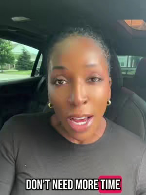A woman is centered in the frame, speaking directly to the camera. She has short, styled, dark hair and is wearing a dark top. The background blurs, providing minimal context beyond the vehicle interior. Overlayed text reads, 'DON'T NEED MORE TIME' within a bright pink box, and is positioned near the bottom of the image.
