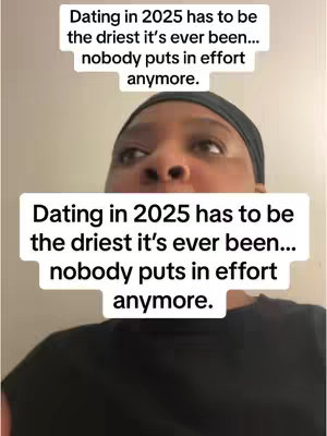 A close-up video showing a person with a black head covering looking up and slightly to the side, seemingly in thought. Rectangular white text boxes in the upper and lower portions of the image display the text, 'Dating in 2025 has to be the driest it's ever been... nobody puts in effort anymore.' The background is a plain, light-colored wall.