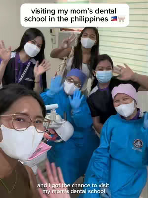 A selfie-style photo featuring a group of smiling people in front of a dental office setting. The main focus is on a woman in the foreground, wearing glasses, a mask, and looking at the camera. Other people are in the background, also wearing masks and some waving. Text overlays include the title and a subtitle.