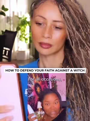 A woman with long braided hair looks directly into the camera holding a phone that displays a video showing a dark-skinned woman. Across the screen, the words 'How to defend your faith against a witch' are written, as well as 'For all occasions'.