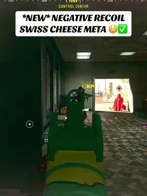 The cover image from a first-person perspective shows a gun in a video game aiming through a corridor into another room where a person is visible. In the foreground, the player's gun is the primary focus, colored in shades of green and yellow. The background suggests an interior setting in a video game, with a control center and a red-clothed figure.