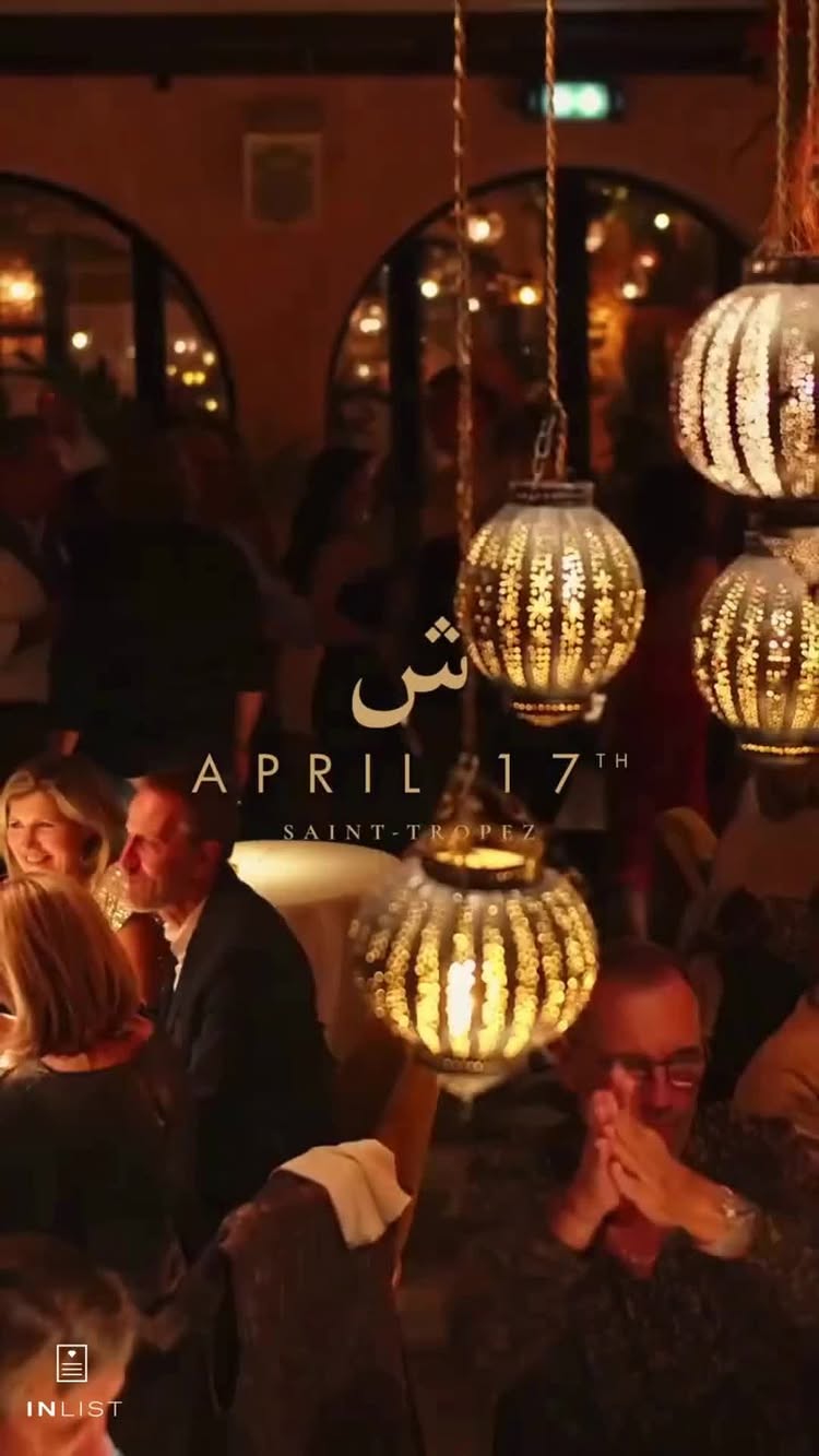 The image showcases a dimly lit restaurant scene. The interior features warm, inviting lights and decorative hanging lanterns. People are seated at tables, engaged in conversation or dining. The overall aesthetic is focused on a sophisticated, exotic ambiance.