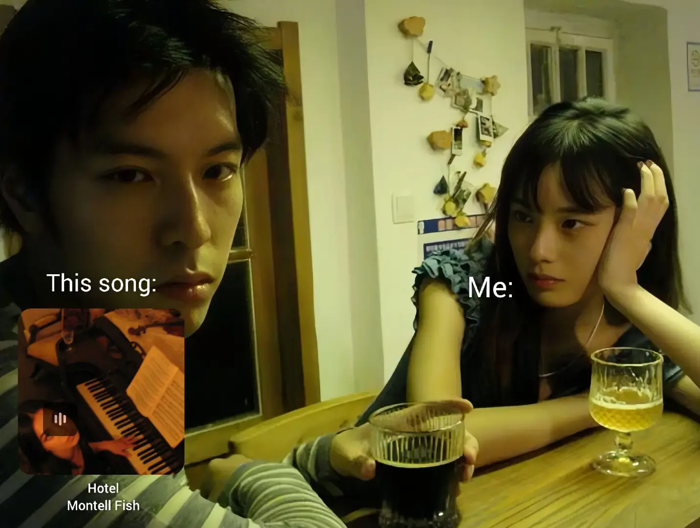 An indoor scene is captured with two young people seated at a table. On the left, a young man with dark hair gazes directly at the viewer, while to the right, a young woman rests her head on her hand. A graphic overlay featuring a music album cover is on the left. The setting appears to be a bar or a home with soft, warm lighting creating a relaxed vibe, with elements like a floral arrangement and decorations in the background.