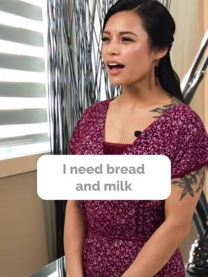 A woman with dark hair and a floral dress stands in front of a window. A text overlay reads, "I need bread and milk."