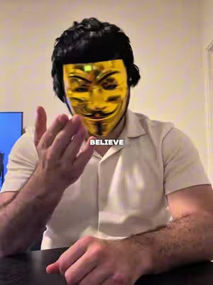 A person wearing a gold mask in front of a blurred background, posing and gesturing with a hand, with text overlayed.
