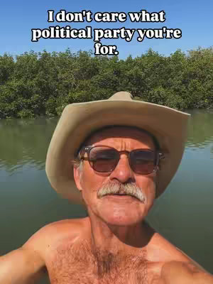 A man in a cowboy hat and sunglasses is taking a selfie from a boat. The background shows trees and water, and above the man's head, there is text overlayed on the image
