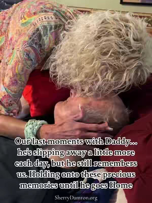 The image portrays an emotional scene. A person in a colorful shirt is embracing an older person with white hair. The older person's face is visible, resting against them,  with a hand holding theirs. Text overlayed on the image shares a heartfelt message about holding onto memories.