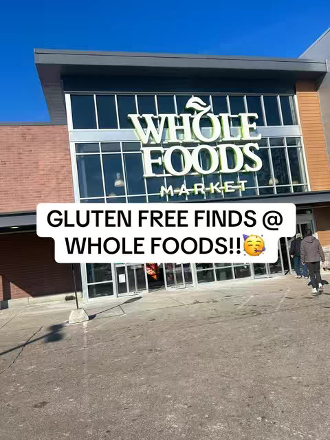 The cover image features the exterior of a Whole Foods Market store, with its large 'WHOLE FOODS MARKET' sign prominently displayed. Below this, a white banner reads 'GLUTEN FREE FINDS @ WHOLE FOODS!!' The overall image presents a bright, outdoor daytime shot, likely taken to attract viewers interested in gluten-free food options.