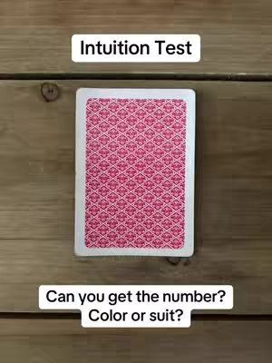 The image shows the back of a playing card centered on a wooden surface. Above the card is a white rectangle labeled 'Intuition Test,' and below the card are two white rectangles with the questions 'Can you get the number?' and 'Color or suit?.' The card's design is a repeating pattern of pink and white shapes. The wooden background appears to be rustic. The image is well-lit.
