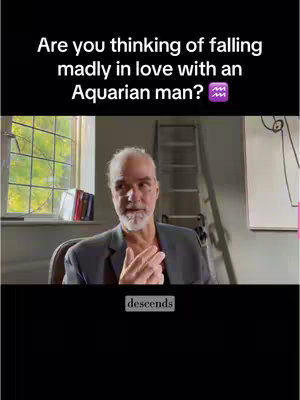 A man with gray hair and a beard is seated indoors, looking at the camera with a slight smile. The background includes a window, a desk with books, a ladder, and what appears to be a whiteboard. Text overlays with questions about astrology are present at the top and bottom of the screen.