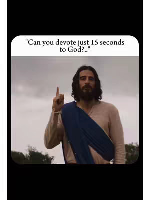 The image features a man styled to resemble Jesus, standing outdoors with an overcast sky as a backdrop. He wears a beige robe and a blue wrap over his shoulder, and has long, dark hair and a beard. He is pointing upward with his right index finger, with a text overlay at the top left saying, "Can you devote just 15 seconds to God?.."