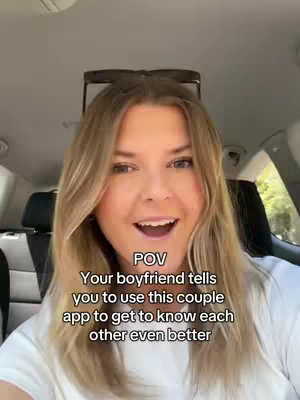 A selfie-style video cover image featuring a woman inside a car. She has blonde hair, is smiling, and appears to be talking to the camera. Overlay text at the bottom of the frame reads "POV Your boyfriend tells you to use this couple app to get to know each other even better."