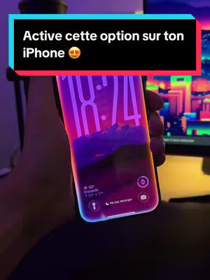 Cover image shows a person holding up a phone displaying the time and weather info. A text overlay at the top says "Active cette option sur ton iPhone". The phone screen glows with a gradient purple and pink. The image is generally dark with only the screen and text being bright.