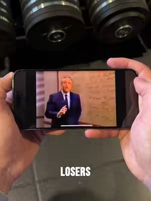 The cover image shows a person holding a phone, and the screen displays a video of a man in a suit. The background features what appears to be weight plates.  The text overlay at the bottom reads "LOSERS".