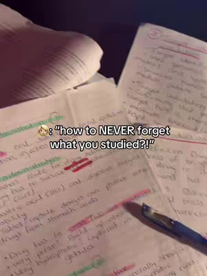 A close-up shot of handwritten notes on paper, with a pen and a notebook visible. The notes are filled with text and annotations using different color highlighting. A text overlay stating 'how to NEVER forget what you studied?!' with a face emoji is positioned towards the center of the image.