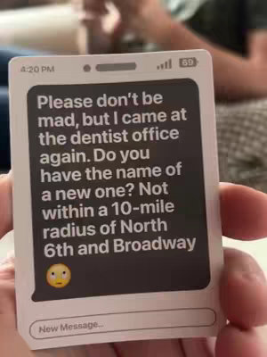 A close-up of a smartphone-shaped card in someone's hand, displaying a text message. The text asks what the person did at the dentist office and asks for the name of a new one.