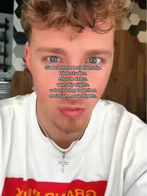 A selfie-style shot featuring a young man with light skin, short, tousled blonde hair, and blue eyes. He is looking directly at the camera with a slight, neutral expression. He is wearing a white t-shirt with a red and black design visible at the bottom. The background appears blurred, with hints of a white textured wall. Text is overlaid on the image, listing relationship concepts.