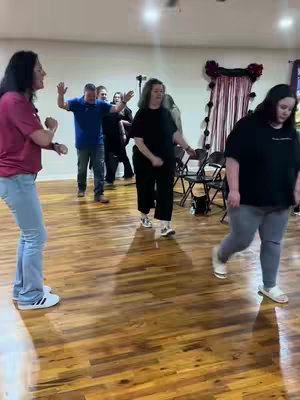 The cover image shows a group of people in what appears to be a studio or large room with a wooden floor, dancing. The individuals are informally dressed; some are actively participating in a dance-like activity. The lighting is bright, creating a sense of openness. The room has minimal decorations.