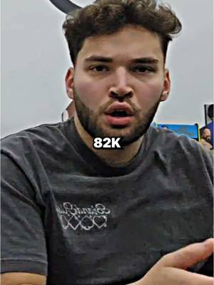 A man with short curly brown hair and a beard is looking directly at the camera with his mouth slightly open. He is wearing a dark t-shirt. In the lower center of the image, there is a text overlay that reads '82K'. The background is out of focus. The overall composition is a selfie or close-up shot.