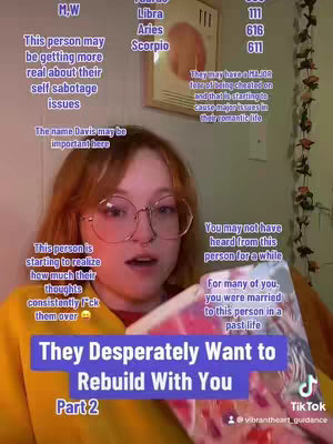 A young woman with red hair and round glasses is speaking to the camera, holding a book with colorful pages. Text overlays are positioned around her, including astrological symbols, personality traits, and phrases like 'They Desperately Want to Rebuild With You.' Other elements include a whiteboard with text and drawings in the background, along with some vines.