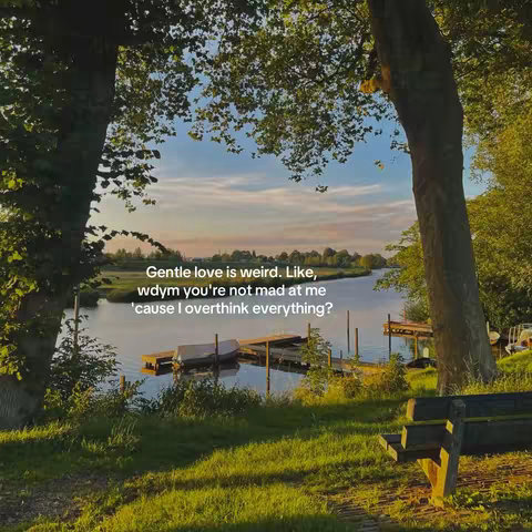 A scenic landscape featuring a serene lake surrounded by lush greenery and trees. A wooden dock extends into the water, with a few boats docked. Text overlayed on the image displays a message about gentle love.
