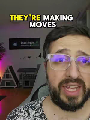 A close-up shot of a man with glasses. Above him is yellow text that says "THEY'RE MAKING MOVES". Behind him, on a wall, is a logo and some cartoon silhouettes. The man has a beard and is looking directly at the viewer.