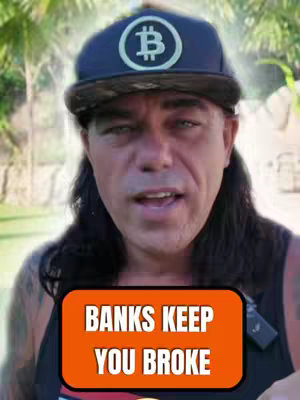 A medium shot features a man in the center wearing a black cap with a Bitcoin logo. He has long, dark hair and a black tank top. An orange banner at the bottom displays the text 'BANKS KEEP YOU BROKE'. The background suggests an outdoor setting with trees.