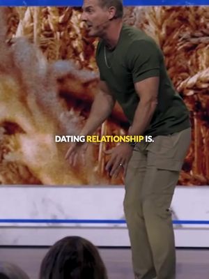 A man in a green shirt and khaki pants is gesturing with his hands, looking to the side. The words DATING RELATIONSHIP IS. are overlaid at the bottom of the image.