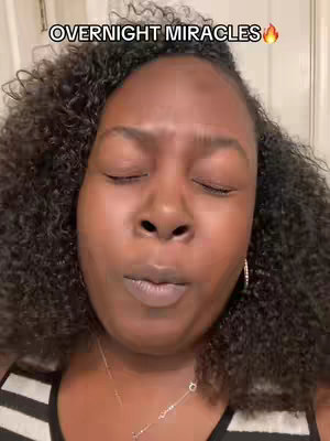 A close-up shot of a woman with dark curly hair gazing upwards with her eyes closed and lips slightly parted as if in prayer. The text overlay 'OVERNIGHT MIRACLES' in white font with a flame emoji next to it is positioned above her head.