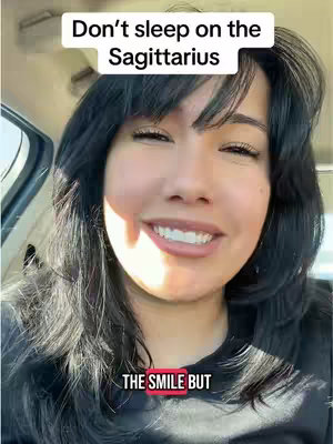 A woman with dark hair and fair skin is smiling while sitting presumably inside a car. Text overlays are positioned at the top and the bottom portion of the video on the cover image.
