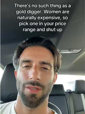 A man is sitting in a car, looking at the camera. Text is overlaid on the image.