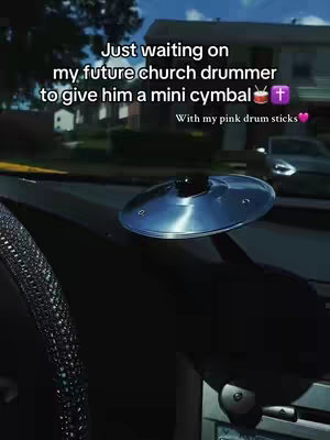 The image captures a close-up view inside a car, focusing on the dashboard. A shiny, circular cymbal sits on the dashboard, catching the light. Text overlays detail the intention to find a church drummer to give the cymbal to. The scene implies a sense of anticipation and a desire for connection, with a religious connotation.