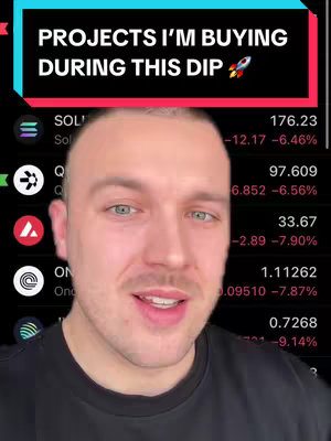 A selfie-style cover image featuring a man centered with a screen behind him displaying stock information. The top third of the image has a black background with bold, white text that reads "PROJECTS I'M BUYING DURING THIS DIP" with a rocket ship emoji at the end, while the remaining two-thirds of the image shows a person in dark clothing. The screen behind shows a list of crypto coins with live market data in a light color. The man in the shot is looking directly into the camera.