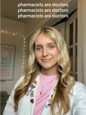 A young woman with blonde hair is smiling at the camera. She wears a pink shirt and a white lab coat, with various pins attached to the coat. Text overlays at the top say 'pharmacists are doctors' repeated multiple times.