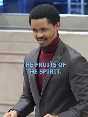 A man, seen from the chest up, stands in a well-lit space and is smiling slightly. He wears a maroon turtleneck under a dark gray blazer. Text overlays the image.