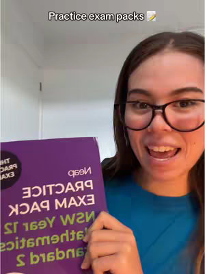 A woman with glasses smiles while holding a book with text in large letters. The text overlay says, "Practice exam packs" at the top.