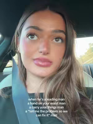 A woman looks up slightly in a car. Text overlay is in white.