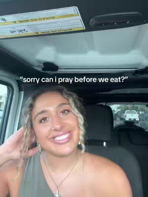 A young woman with curly blonde hair is seated inside a vehicle, possibly a car or SUV. She has a direct gaze, a slight smile, and is mid-sentence. The background shows the vehicle's interior, a glimpse of an outdoor setting, and text overlaid on the image to indicate the video's context.