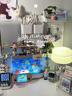 A well-lit setup featuring a desk adorned with various items, including an aquarium, a handheld gaming device, a digital clock, and decorative items. The color scheme includes white, blue, and neutral tones.