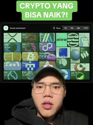 The cover image features a man in a dark hoodie and glasses in front of a screen displaying cryptocurrency information. Above him is a green banner with white text that reads "CRYPTO YANG BISA NAIK?!" The screen behind him shows different cryptocurrency logos and their values. The layout is simple with the man's face taking up a significant portion of the frame, drawing attention to his commentary on the crypto market.