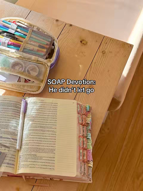 The cover image shows an open Bible on a wooden table, with a pen and tabs. A pencil case in the background.