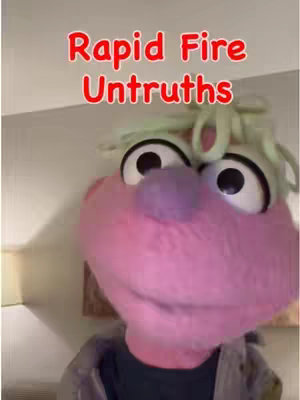 The cover image shows a close-up of a pink puppet-like character with large, dark eyes, a purple nose, and green tufts of hair. The text overlayed in red reads 'Rapid Fire Untruths'.