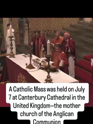 The image captures a scene from a Catholic Mass held at Canterbury Cathedral. The composition features a close-up of the altar with several priests dressed in traditional vestments. A lit candle stands prominently in the center, and the overall lighting suggests an indoor setting. The bottom of the image includes a text overlay providing details about the event.